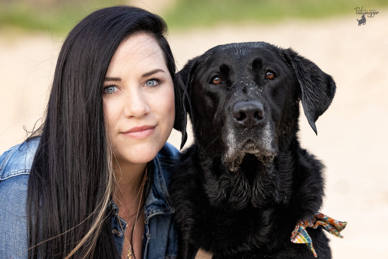 A woman and her male black Lab on the beach at Kruse Dog Beach in Muskegon, MI.